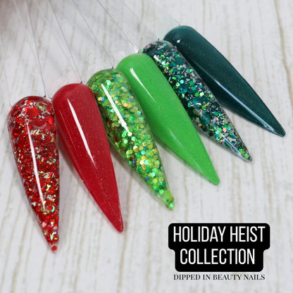Holiday Heist Collection of six Christmas dip powders including red, green, teal, shimmer, glitter, and glow shades.